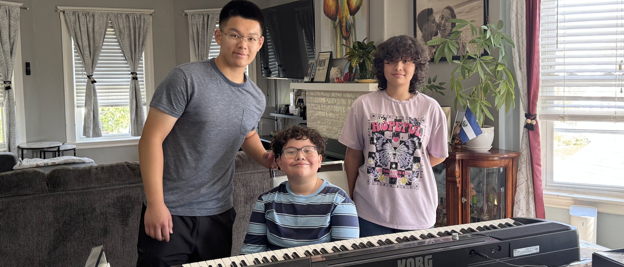 A family in their living room with the digital piano they asked us for.